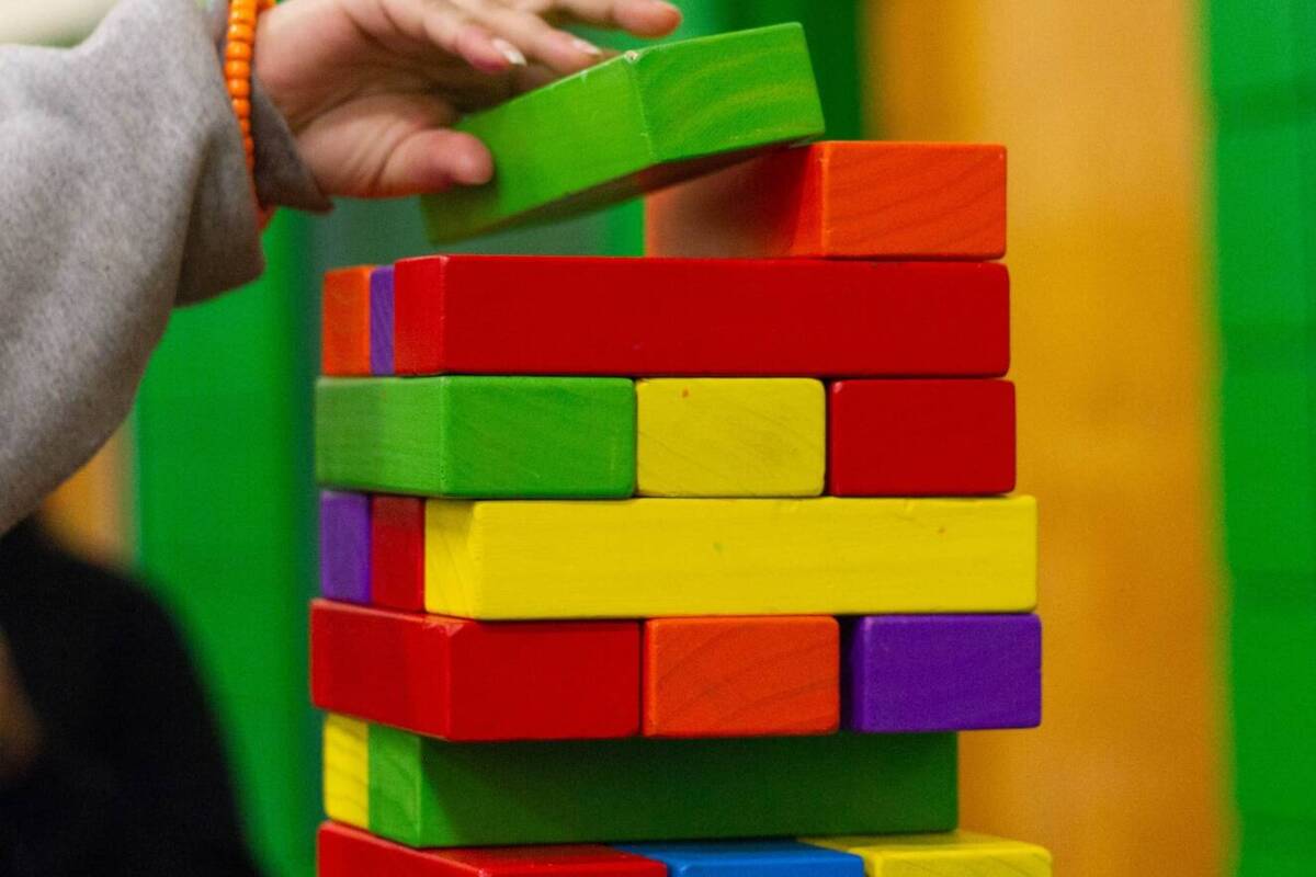 Header Symbolbild: Oberer Teil eines hohen Turms aus bunten Holzbauklötzen